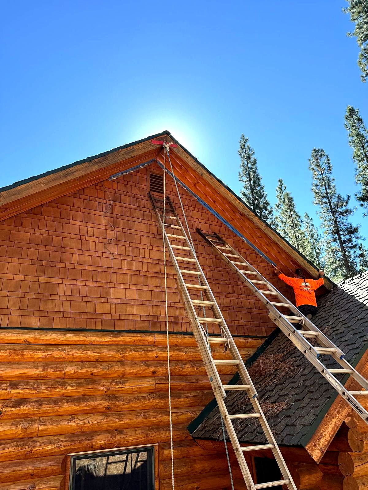 Crew refinishing a wood sided gable from ladders