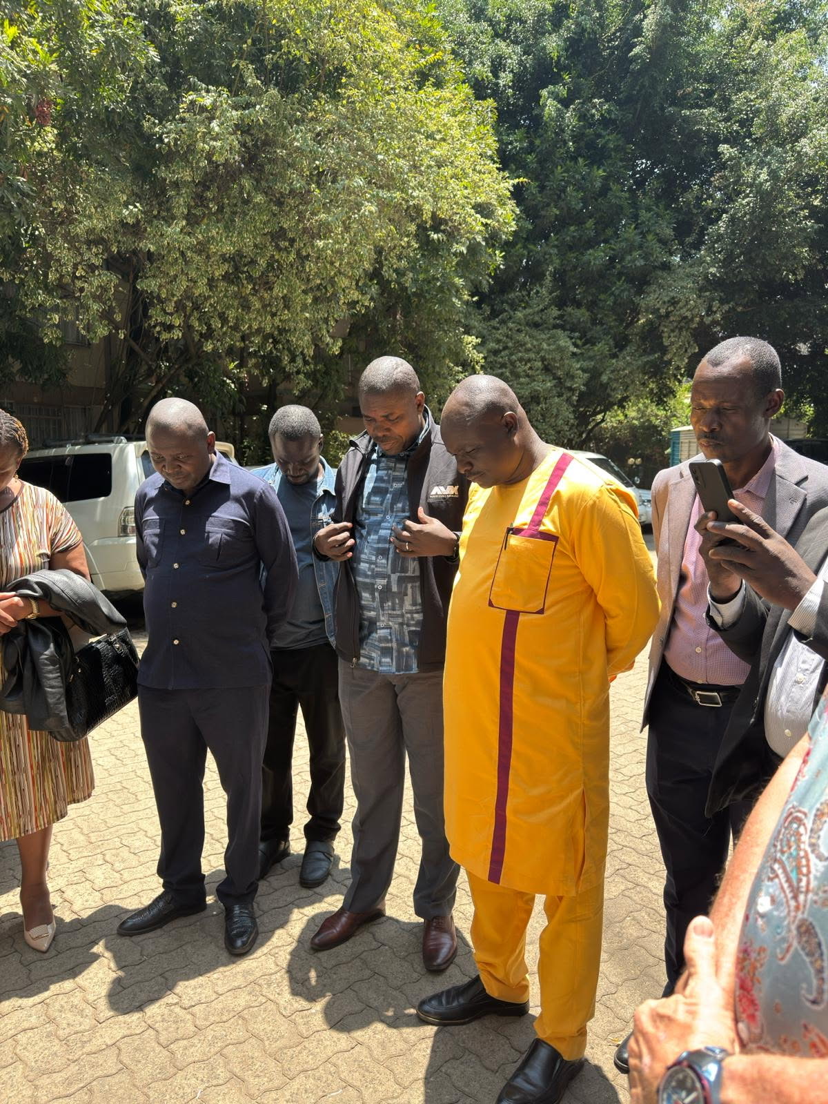 Men praying in parking lot