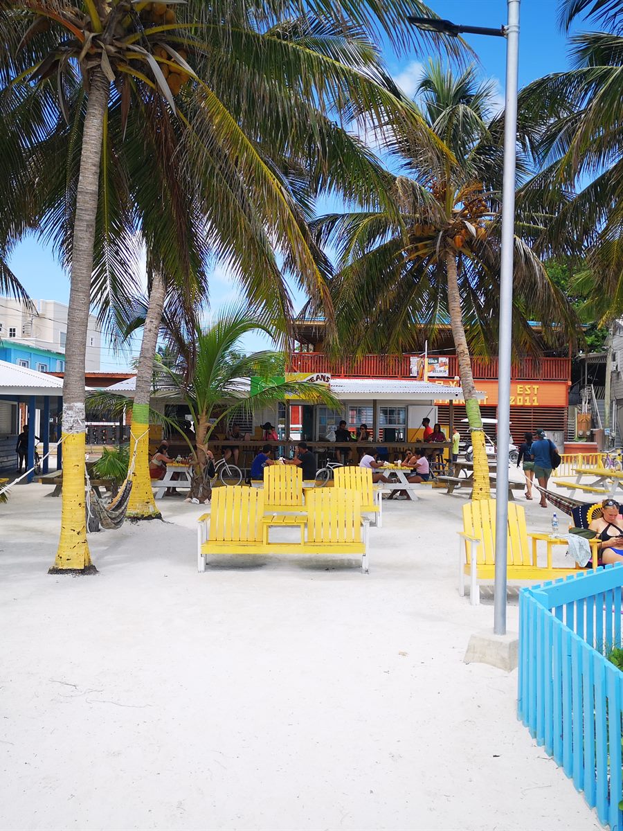 A colourful island street with hammocks and beach chairs