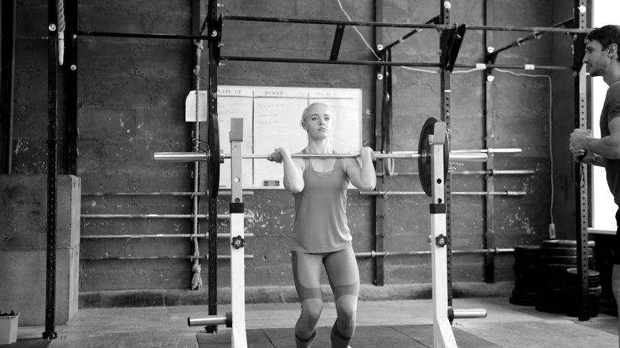 Coach watching an athlete lift a barbell