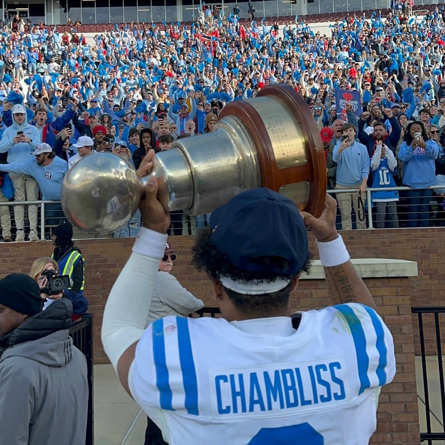 Player lifting a rivalry trophy