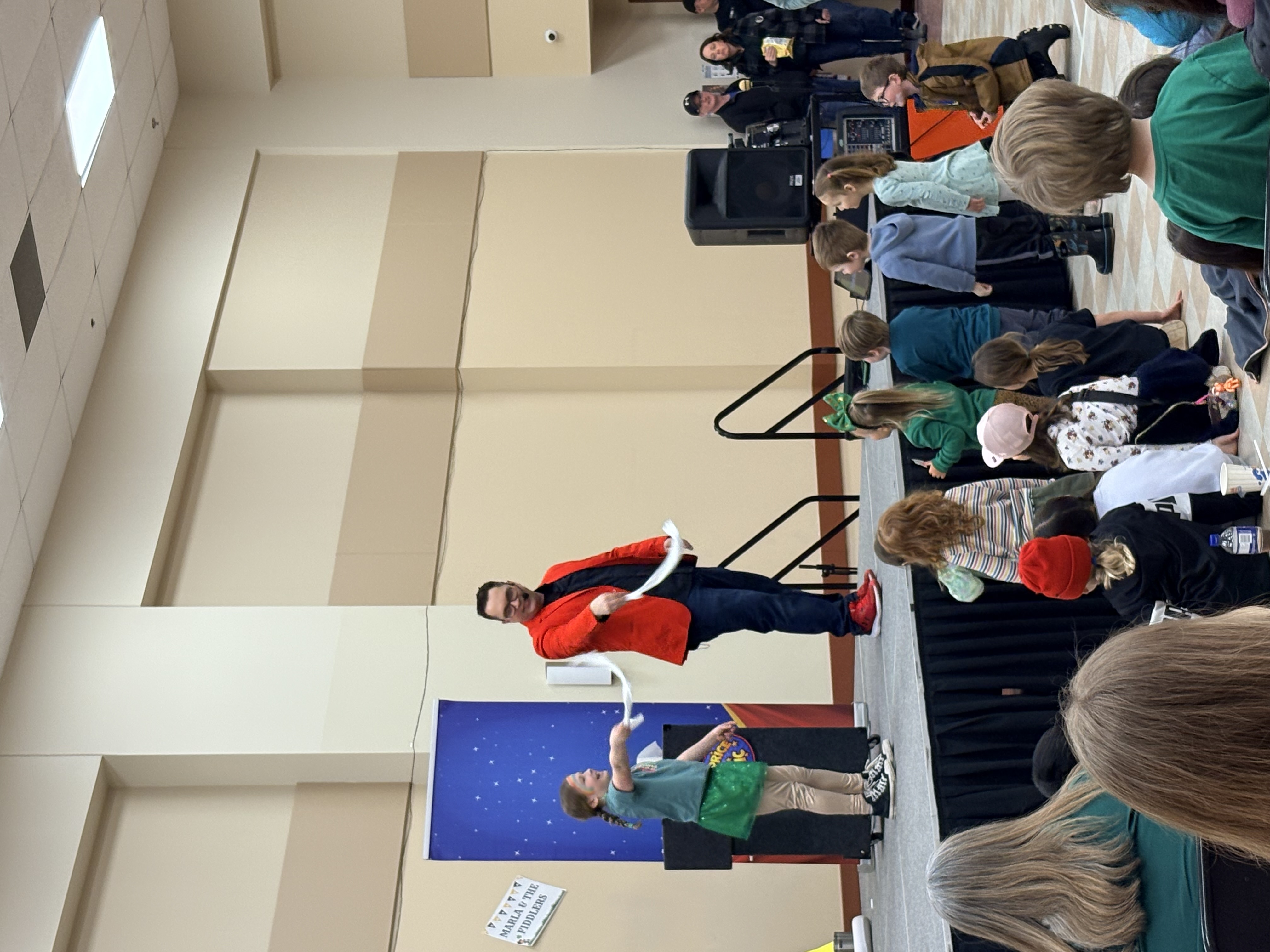Ryan Price performing magic with an excited young volunteer at a family event in Winnipeg