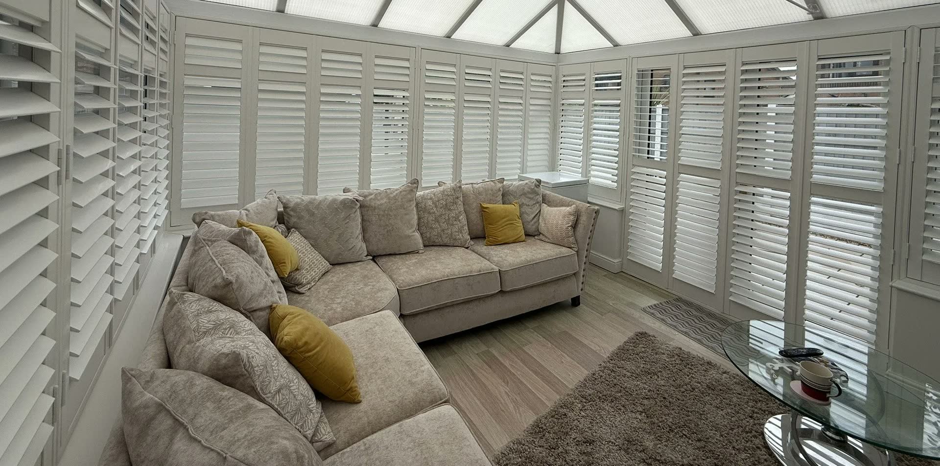 A conservatory fitted with white plantation shutters by Grove