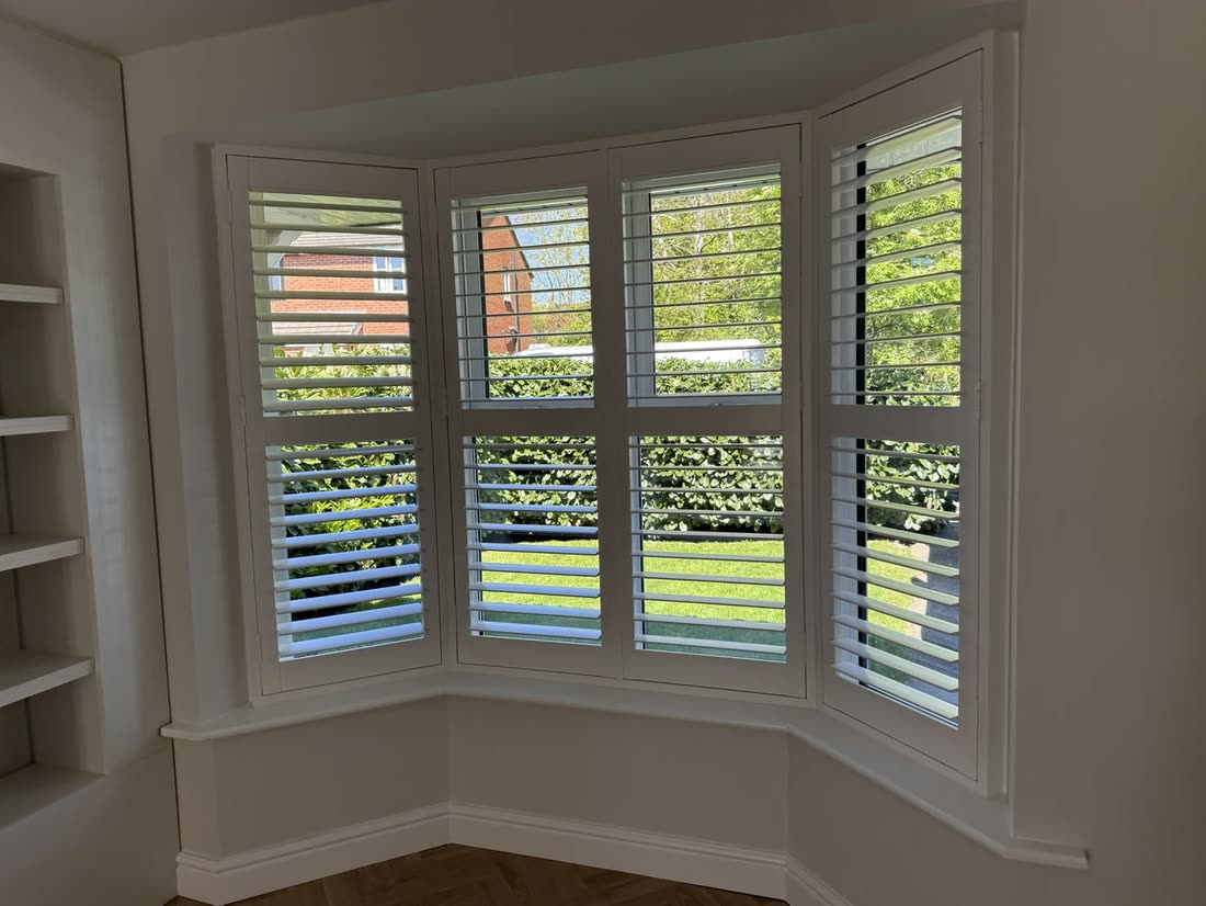 Polymer-coated hardwood shutters in a bay window