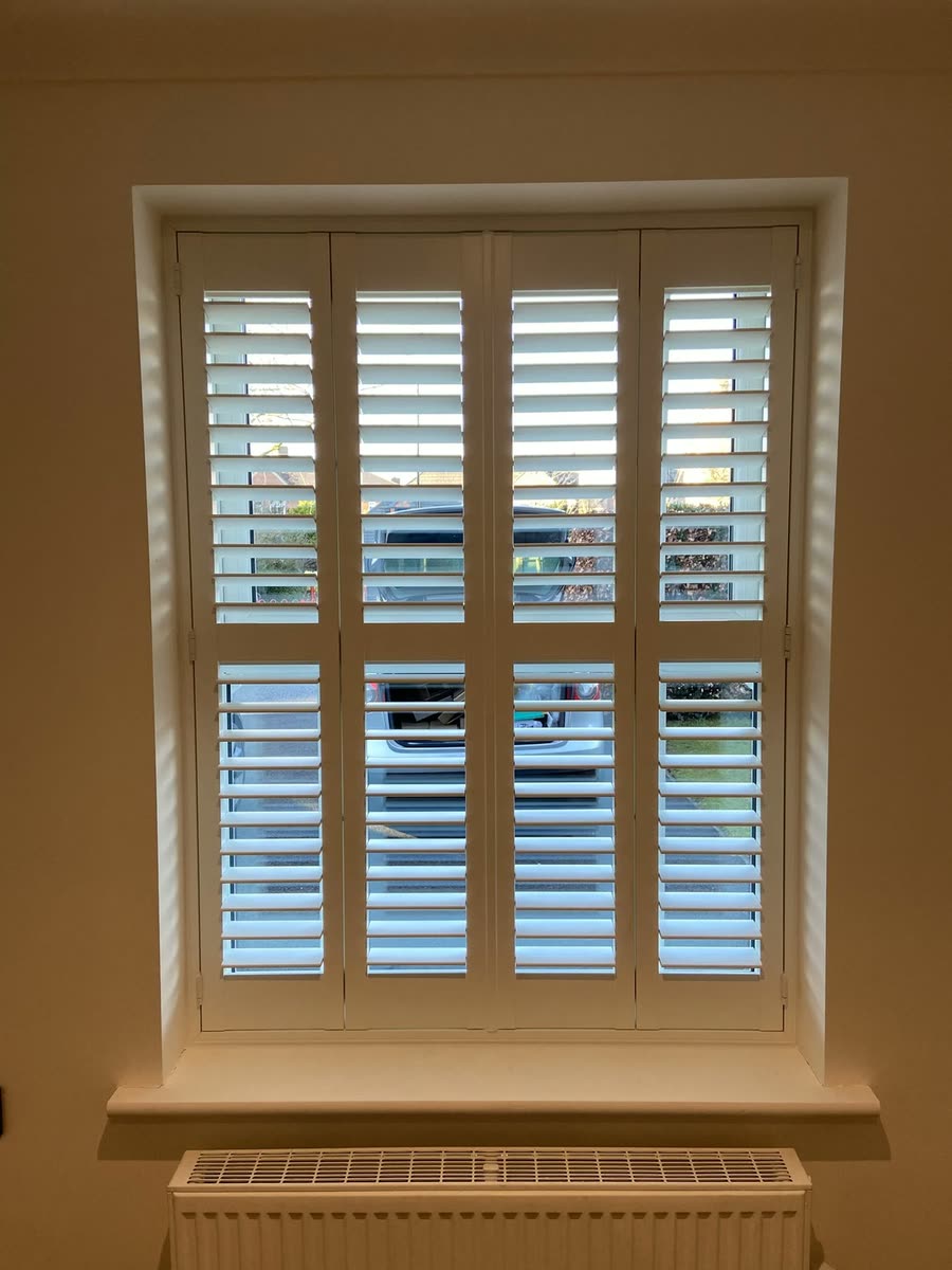 White plantation shutters with a centre rail on a living room window