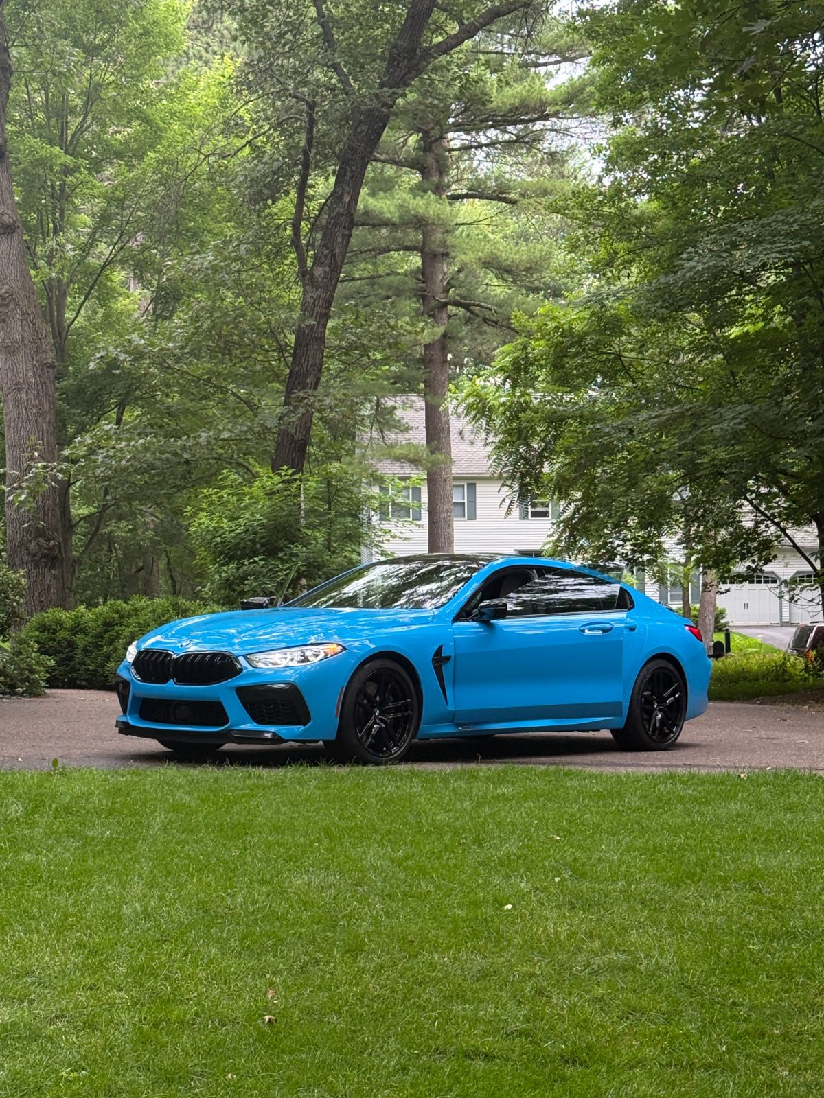 Detailed blue BMW M8 gleaming in the driveway — mobile car detailing Eau Claire