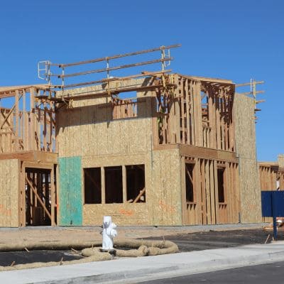 esidential building under construction with exposed wooden framing and scaffolding