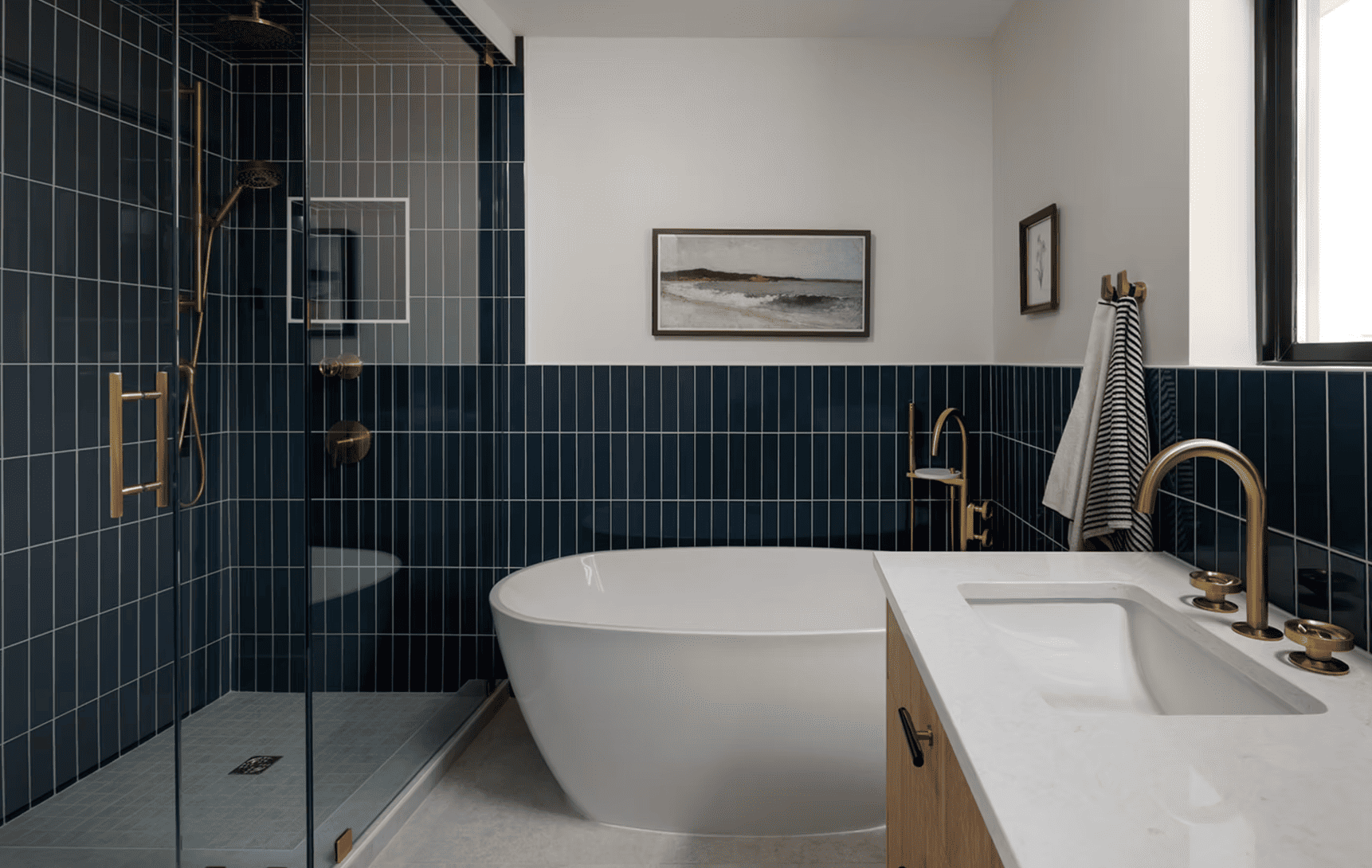 Navy tiled bathroom with freestanding tub and brass fixtures by 3AP Construction