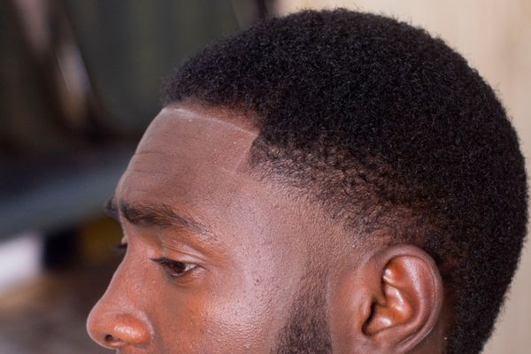 Close-up of a low fade haircut for different hair type showing clean blending on curly textures Close-up of a low fade haircut for different hair type showing clean blending on curly textures