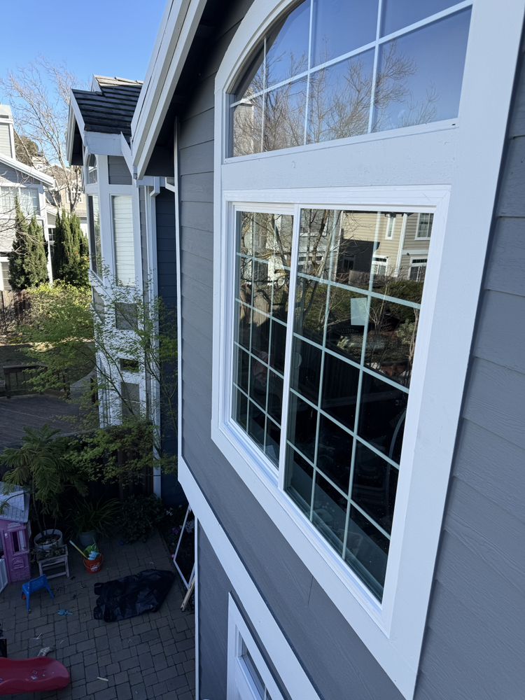 Replacement picture window with arched transom on a two-story home