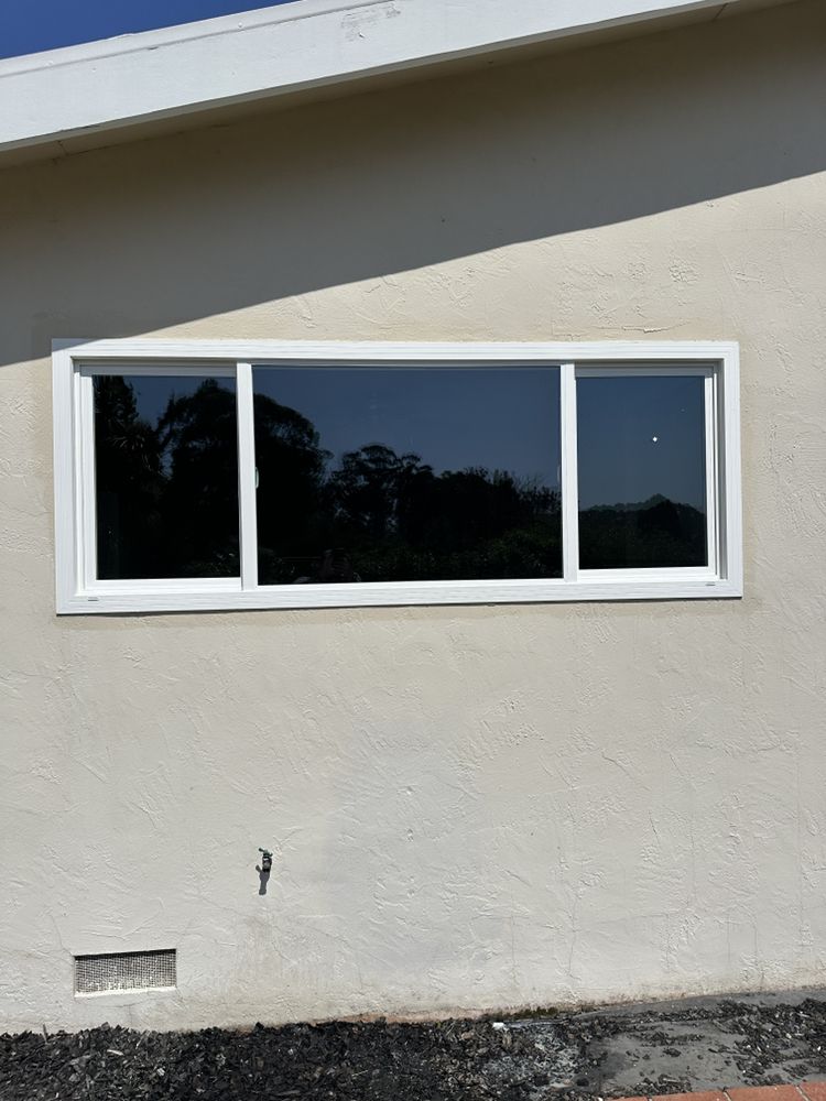New white vinyl sliding window installed in a stucco wall