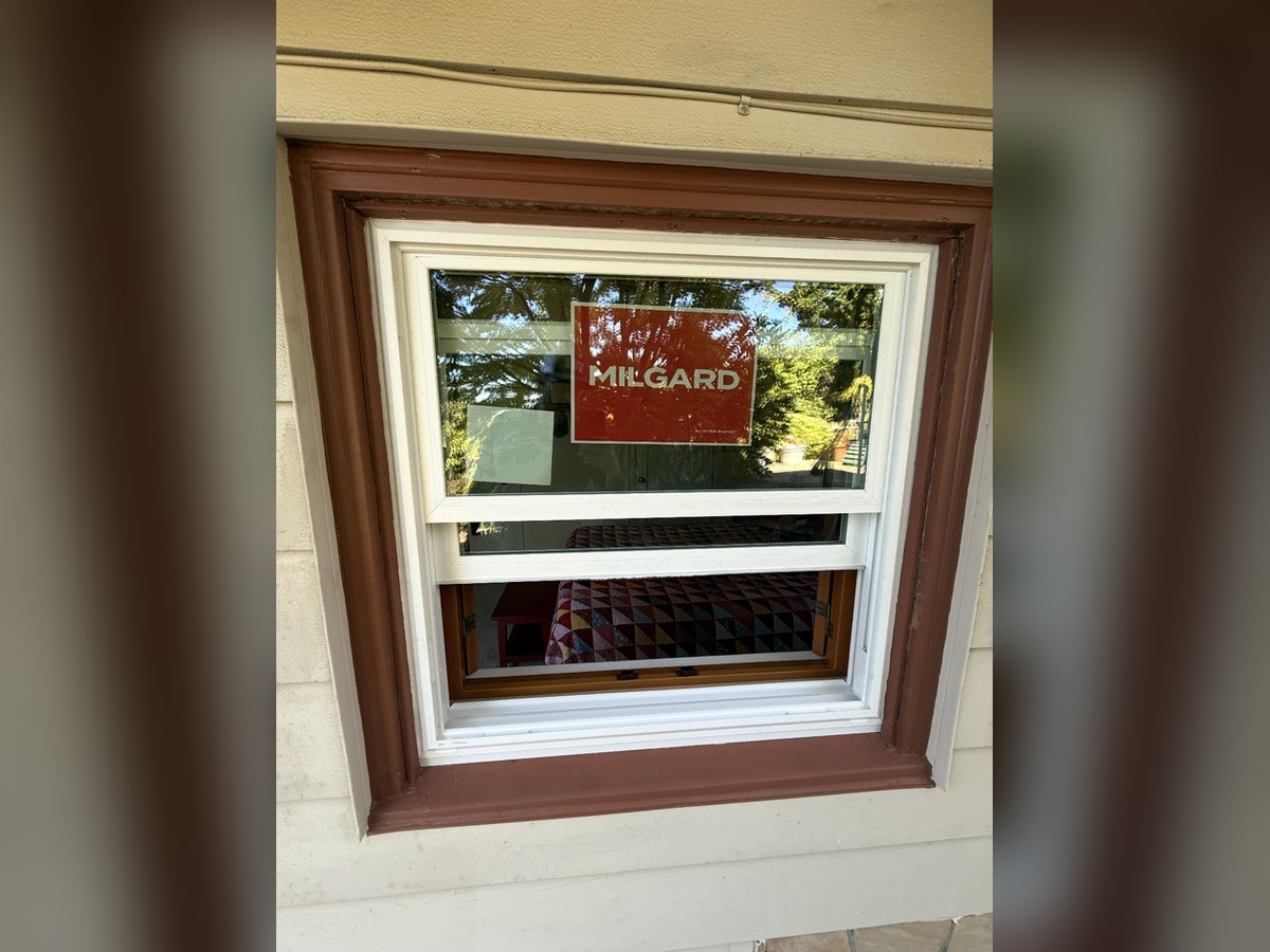 Milgard replacement window installed in a wood trim frame