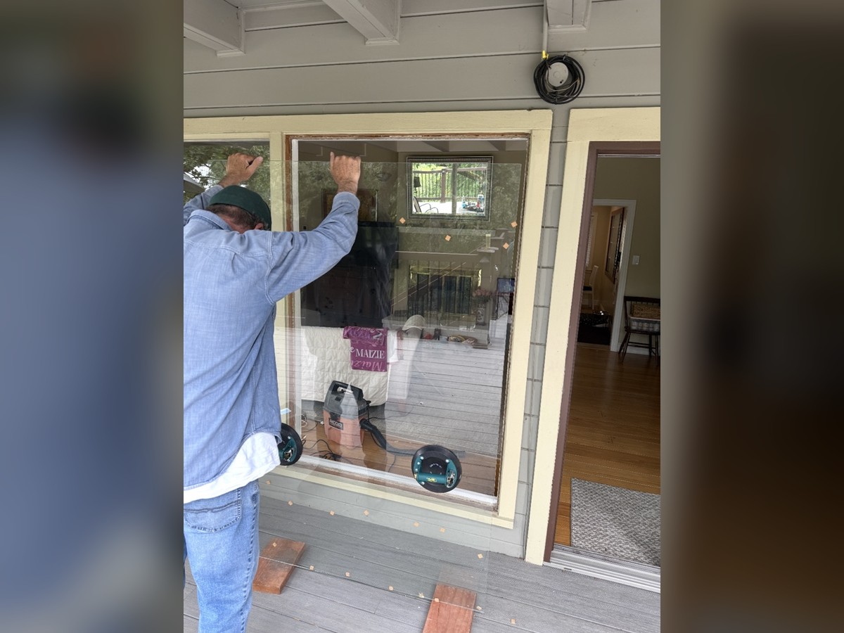 Installer setting a large glass pane with suction cups