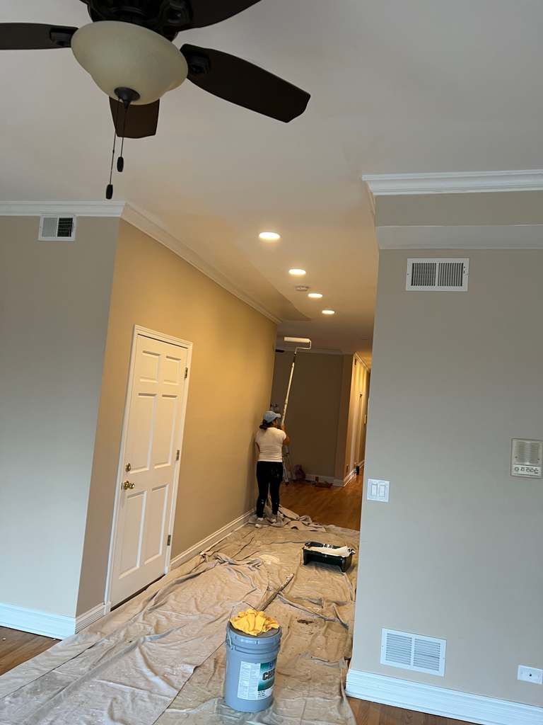 Interior hallway with tan walls and a worker standing near a doorway