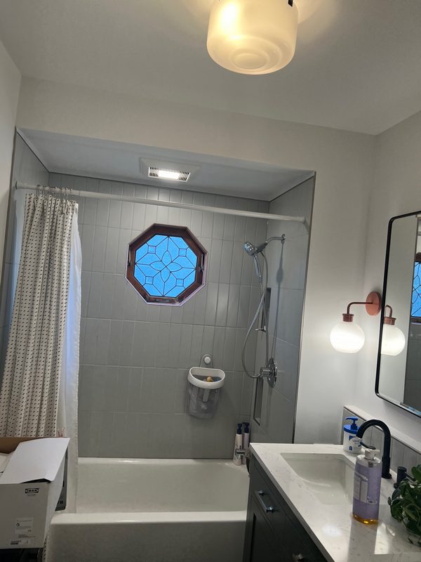 Bathroom with a glass-enclosed shower and a round window