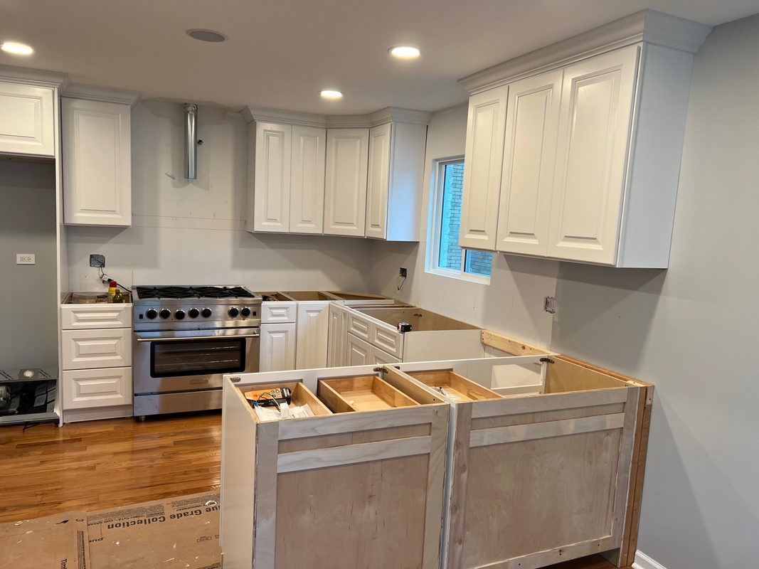 Kitchen with white cabinets, a stainless steel range and wood flooring