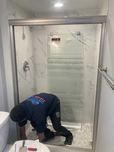Tiled shower with a glass door during a bathroom remodel