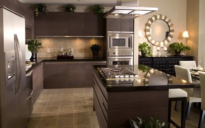 Kitchen with dark cabinets, stainless appliances and a round mirror