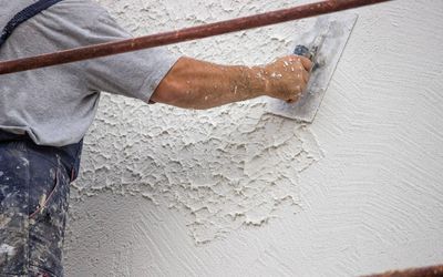 Worker applying plaster to a wall with a trowel