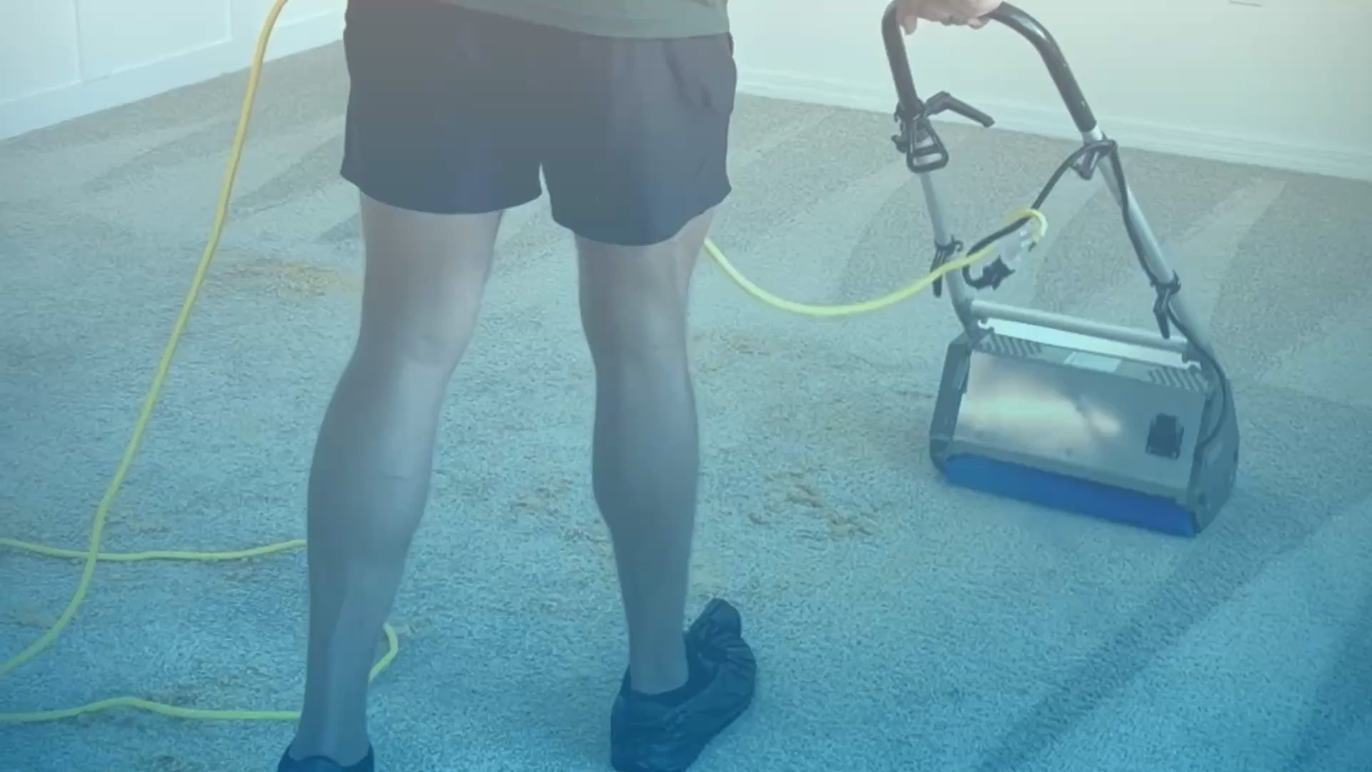 A carpet cleaning machine being run across a carpet in an empty room