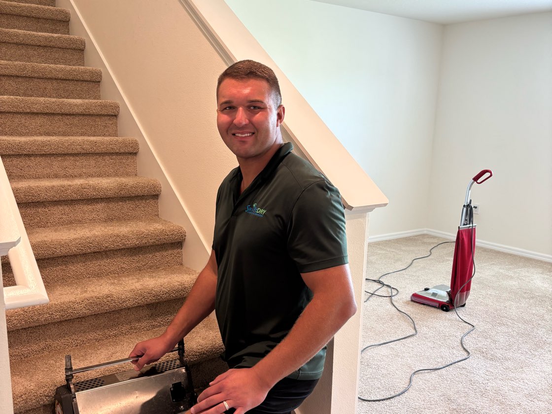A Swift Dry technician cleaning a carpeted staircase with a brush machine