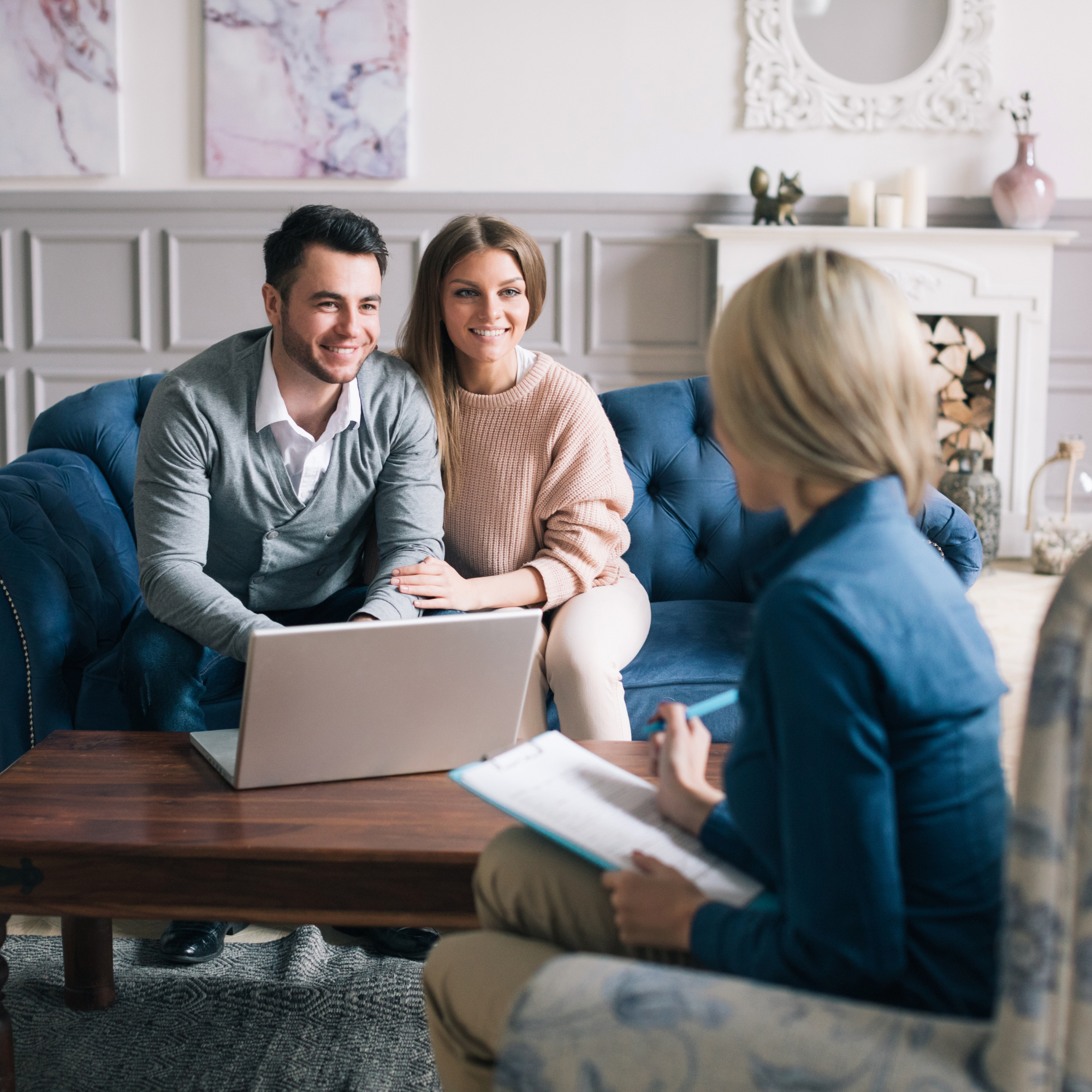 Couple in a relationship coaching session with coach, smiling, laptop on table