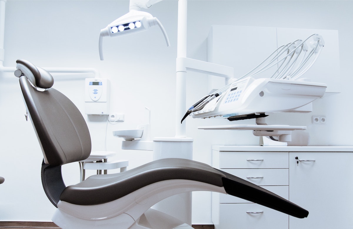 A clean, modern dental treatment room with the chair and overhead light