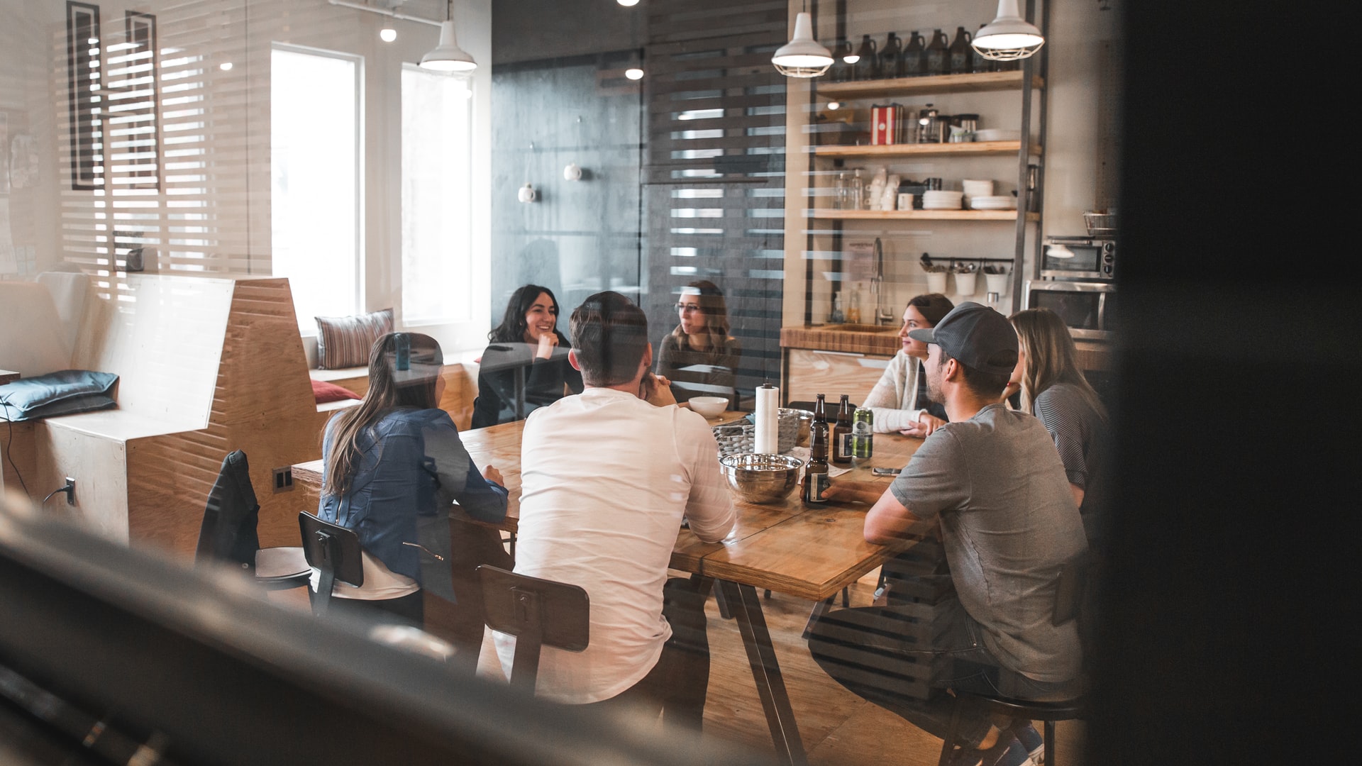 Employees working together at a long table in a shared workspace