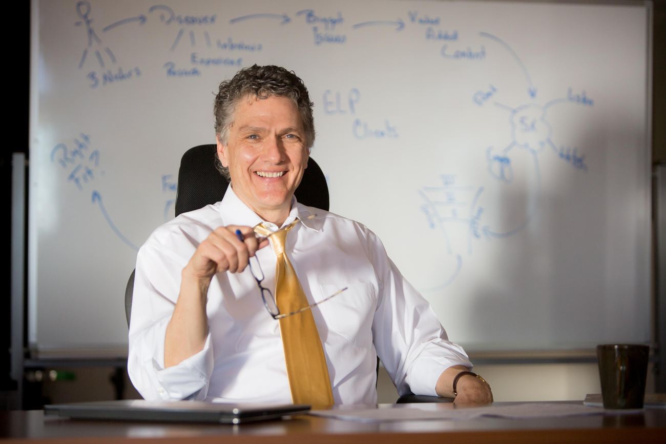 Scott Keffer at his desk in front of a whiteboard of client-attraction frameworks