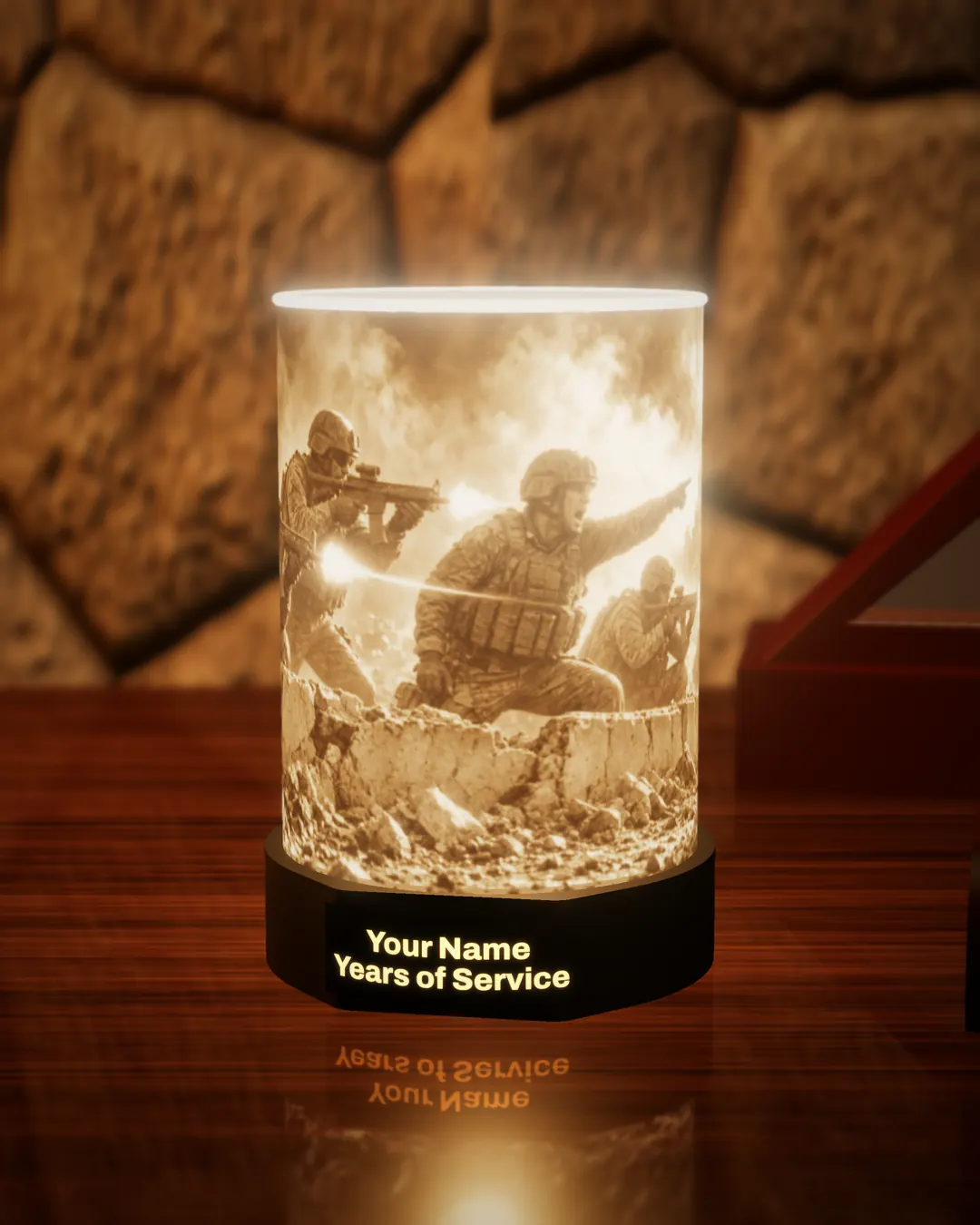 Military combat scene tribute lithophane lamp lit warm, showing soldiers advancing under fire, with the black base nameplate glowing “Your Name / Years of Service”, on a wooden desk against a stone wall