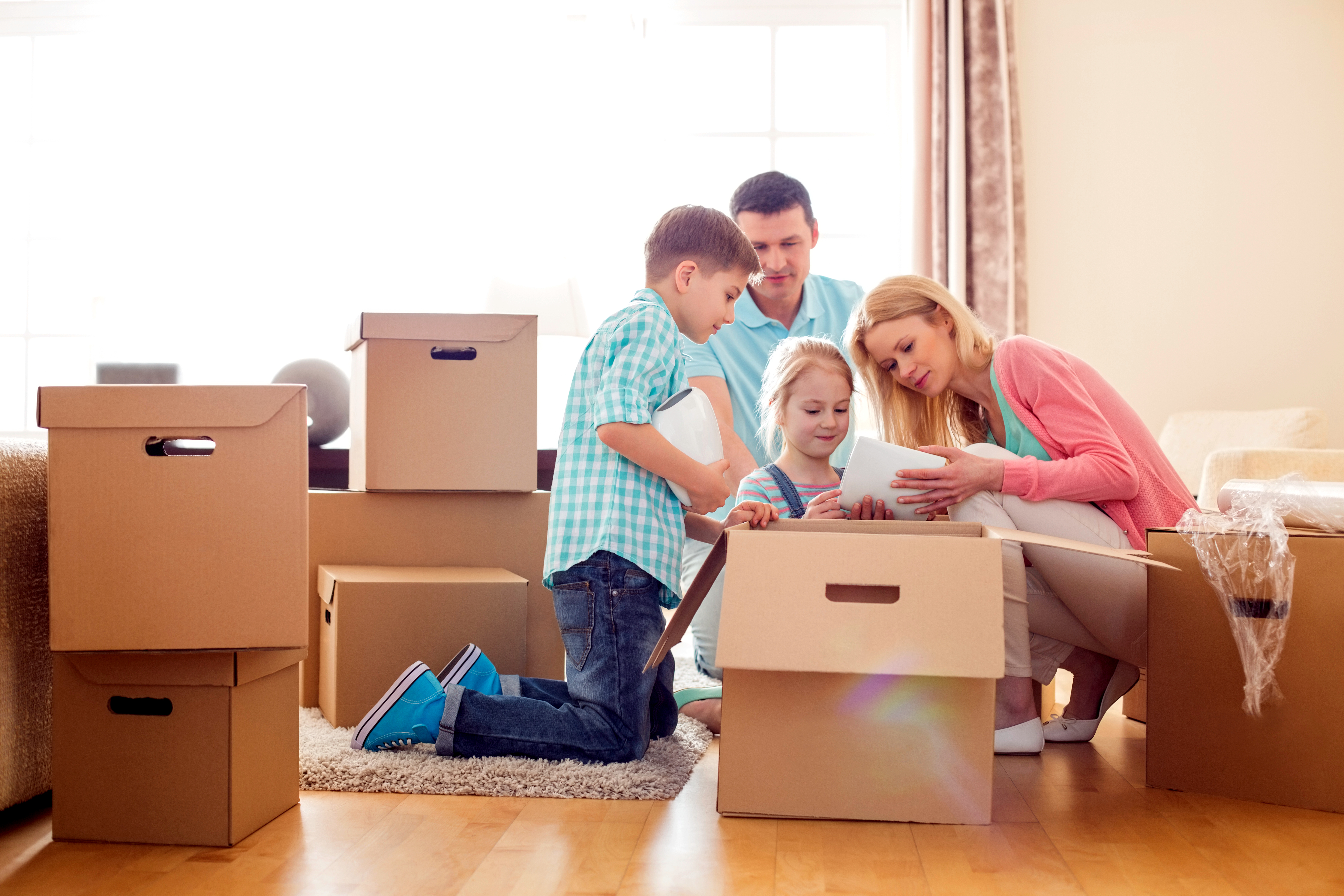 A family unpacking boxes together in their new living room