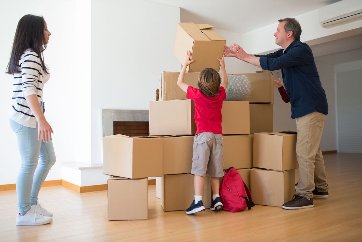 Parents and a child stacking moving boxes