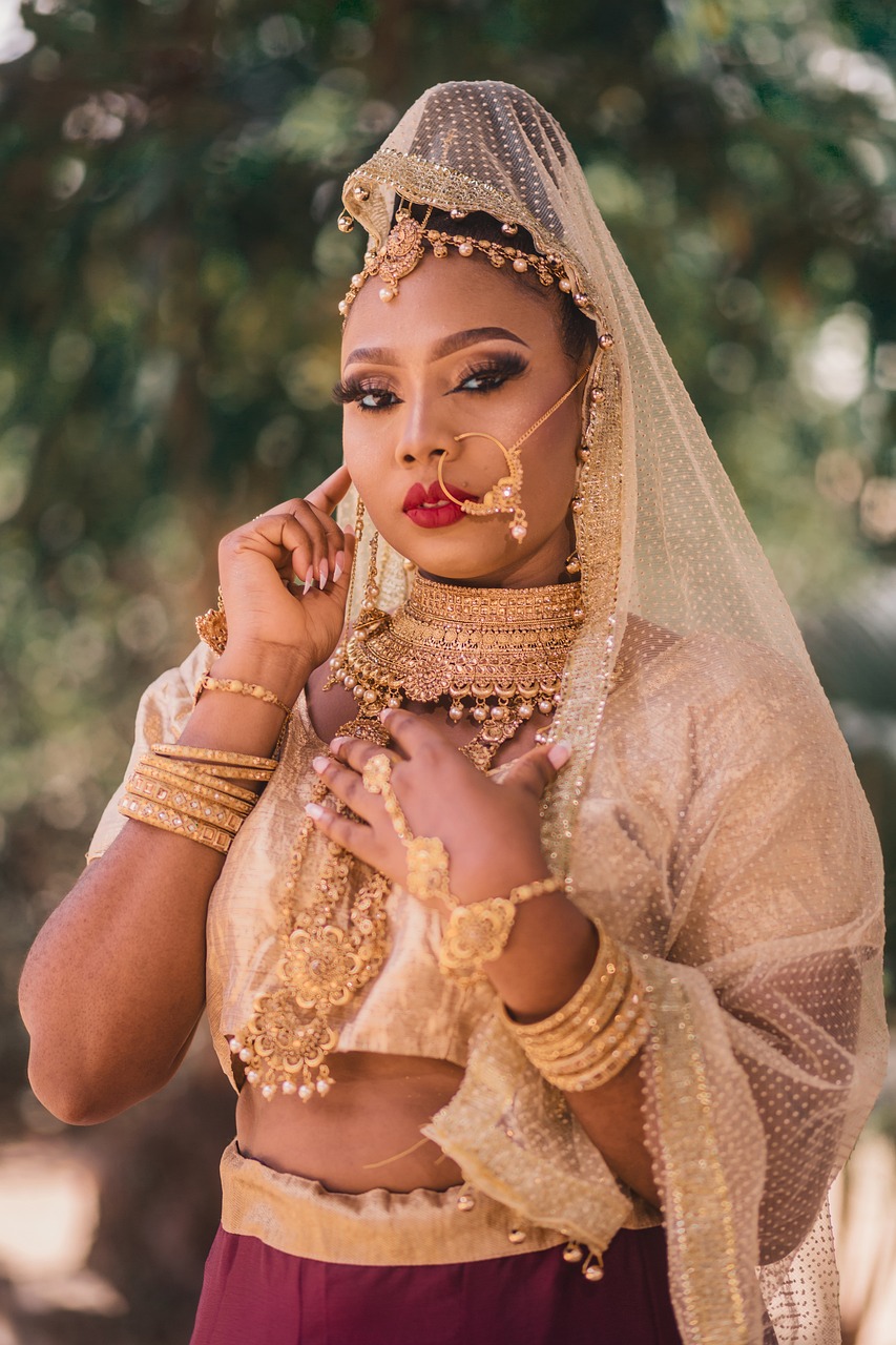Guest in gold jewellery and a veil with full evening makeup for a cultural celebration