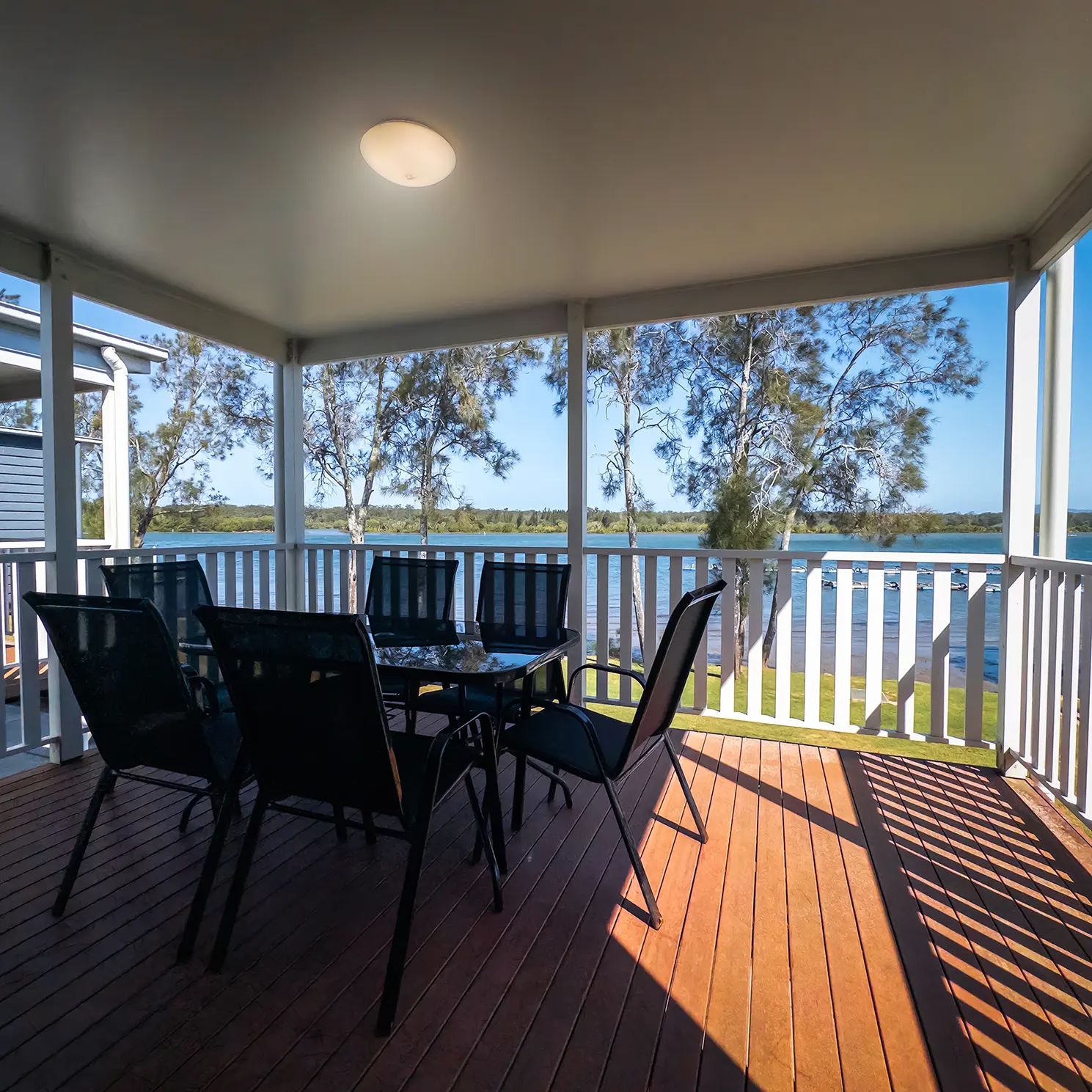 Riverfront cabin dining area with river views, Nambucca Heads