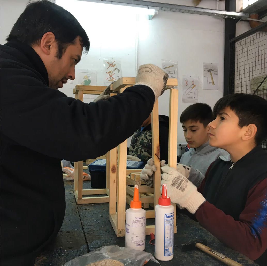 Un profesor con alumnos de los Talleres Tecnológicos en carpintería