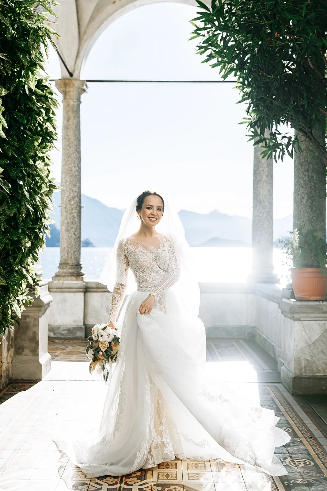 A bride walking happily through an Italian garden on the morning of her wedding