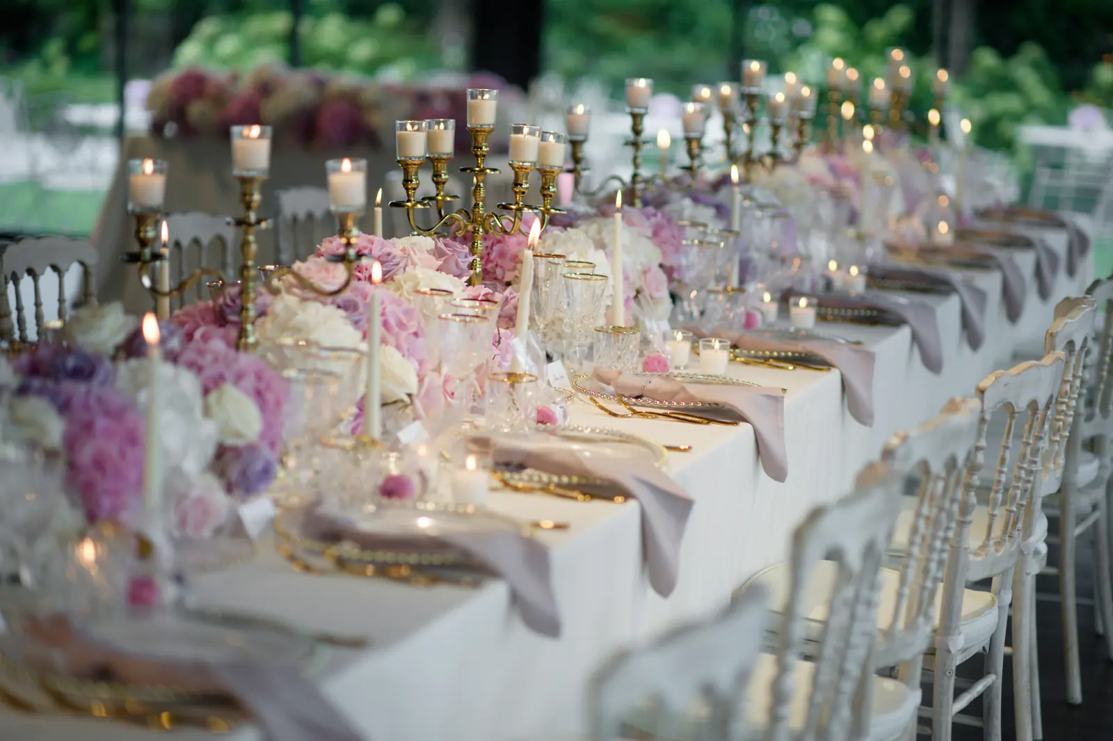 An elegant candlelit wedding table in Italy with linen, seasonal flowers and handwritten place cards