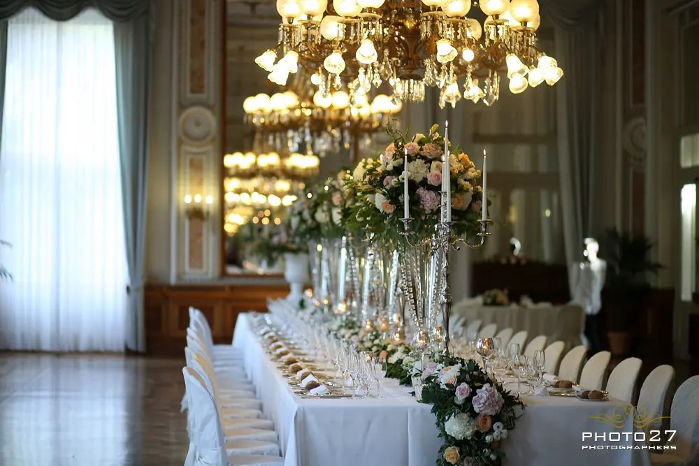 An Italian wedding reception table with candles, linen and seasonal flowers at dusk