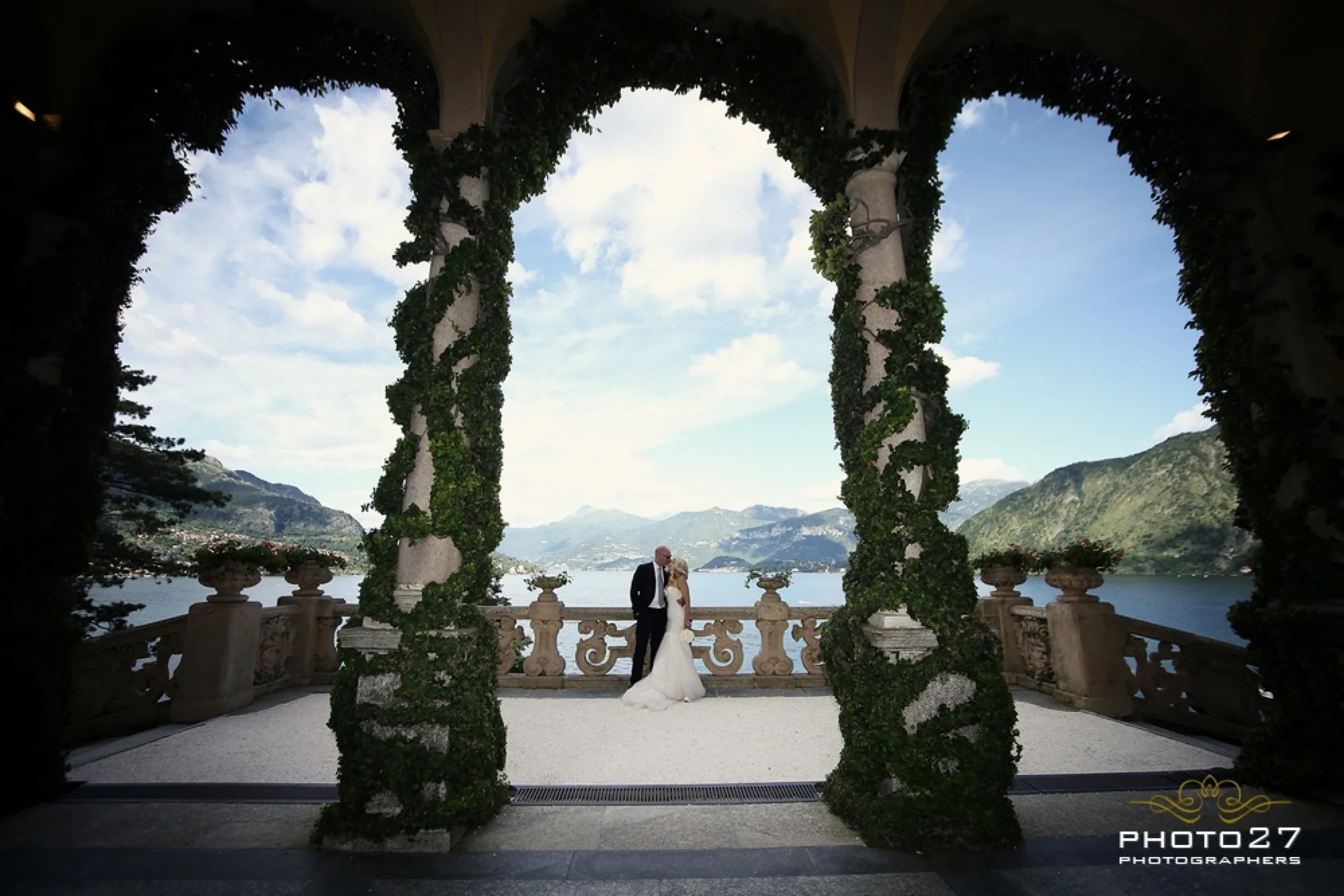 A private boat approaching a historic villa on Lake Como, with mountains reflected in the water