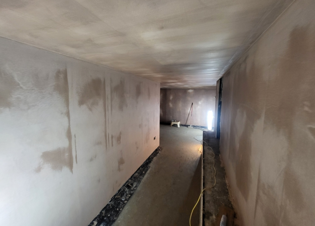 Plasterer applying a smooth skim coat to an interior wall