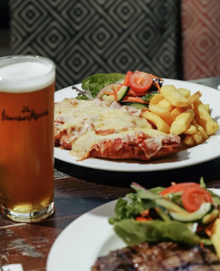Chicken parma with potato wedges, salad and a beer