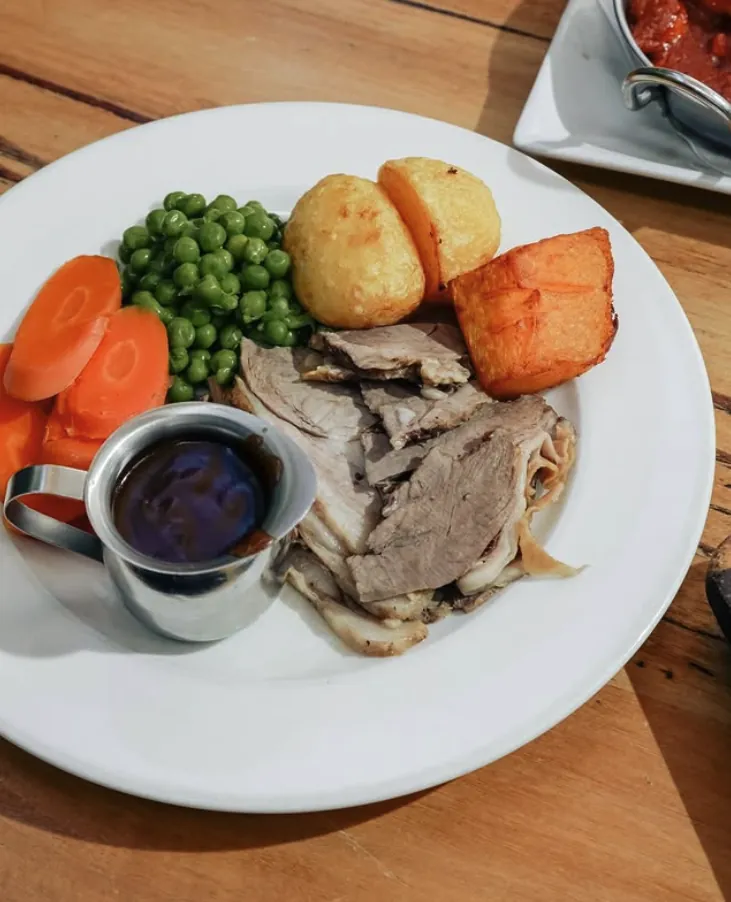 Roast lamb with peas, carrots, roast potatoes and gravy
