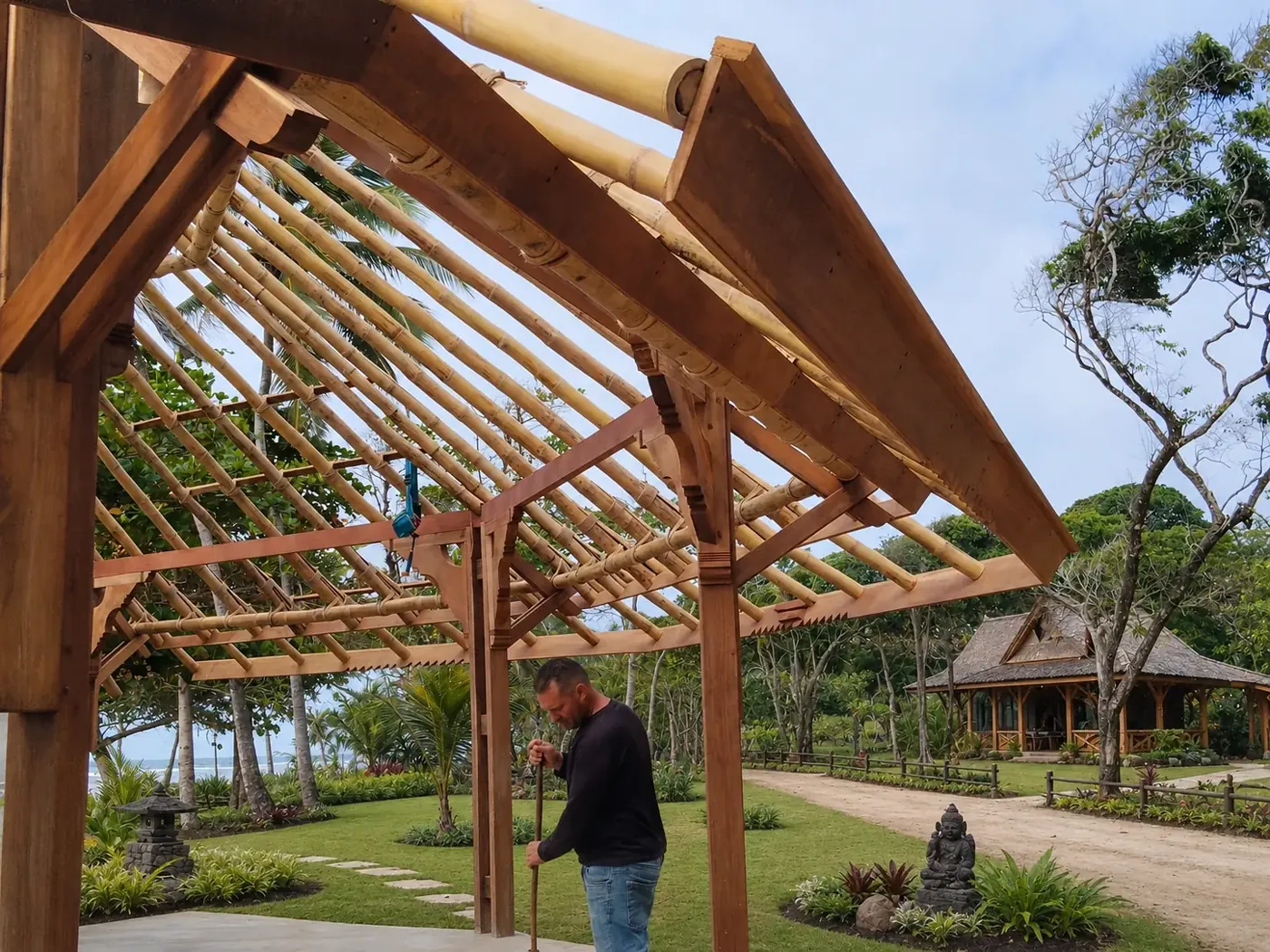 Handcrafted timber frame rising within a tropical garden