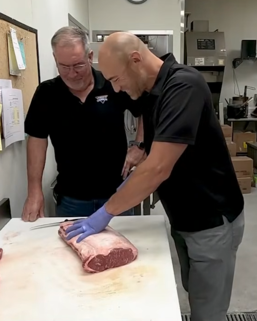 Breaking down a whole ribeye at the cutting table at Jordan Meats & Deli