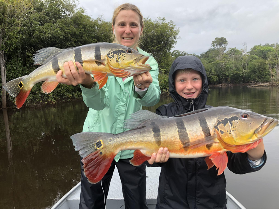 Parent and child fishing for peacock bass