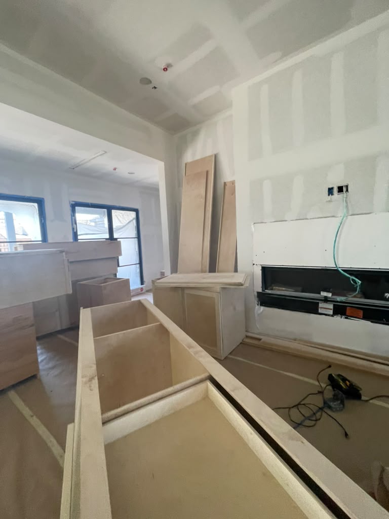 Living room with old wall color and worn trim before painting
