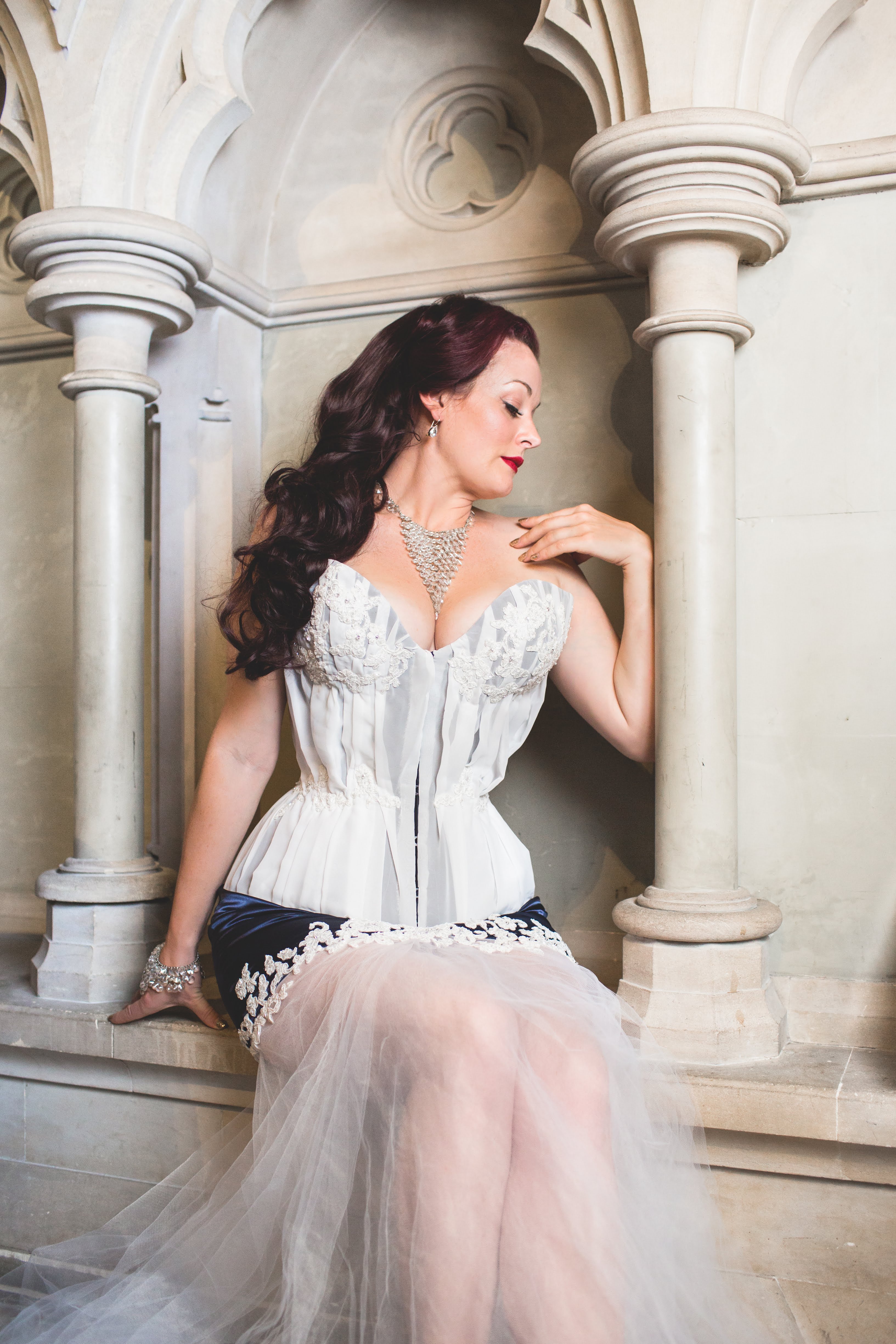 Advanced Corsetry course. A model is wearing a custom corset and posing in a church.