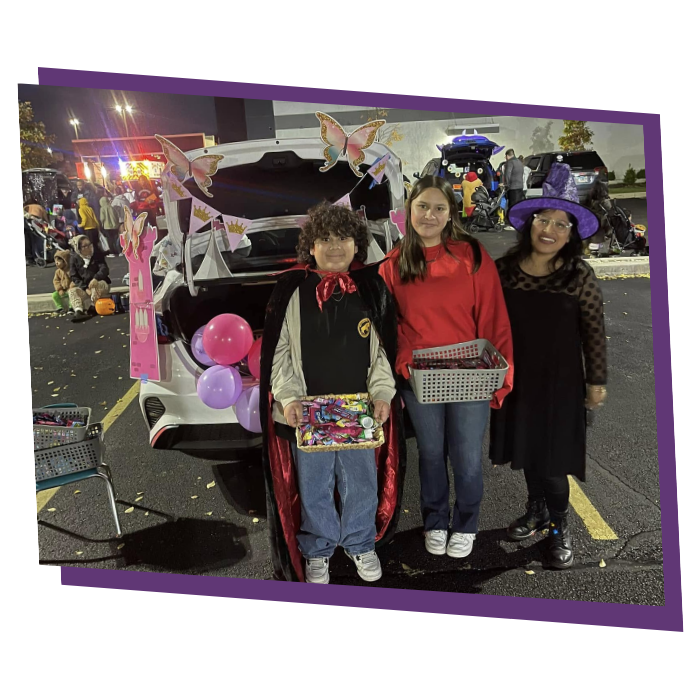 family in halloween costumes at trunk or treat