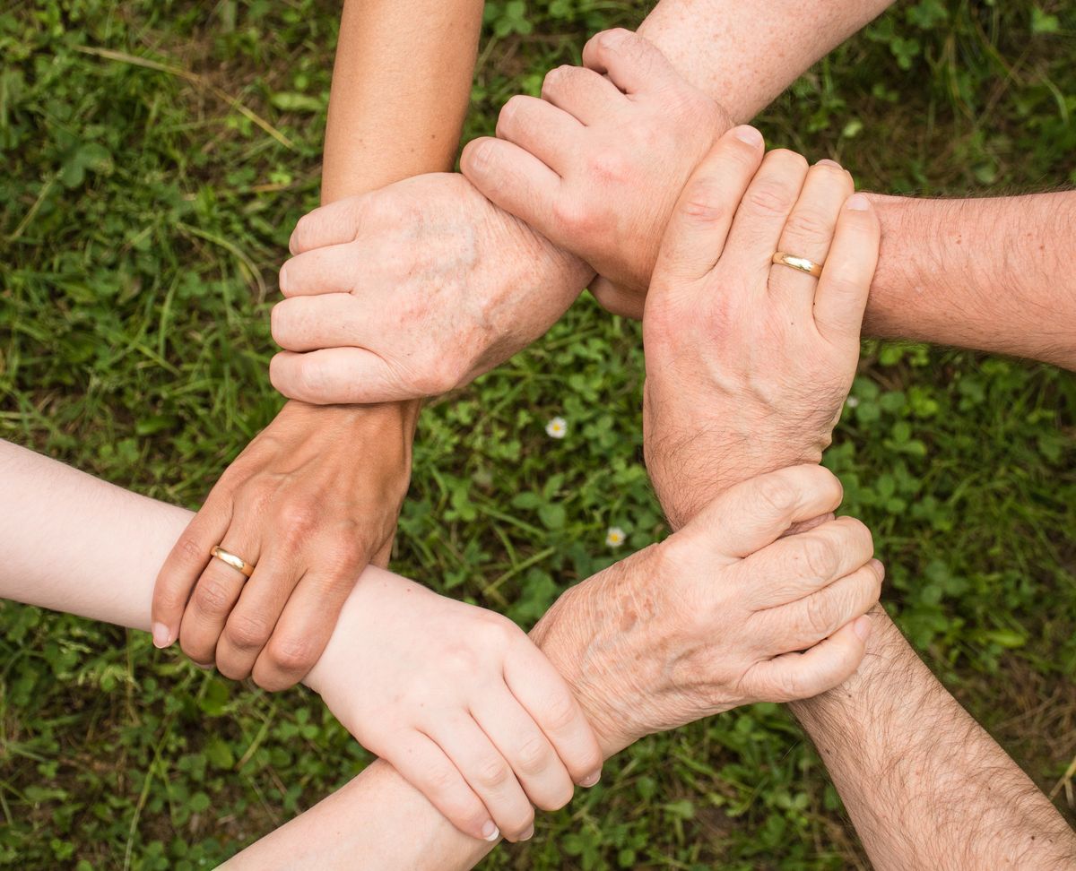 Hands of different generations joined together in a circle