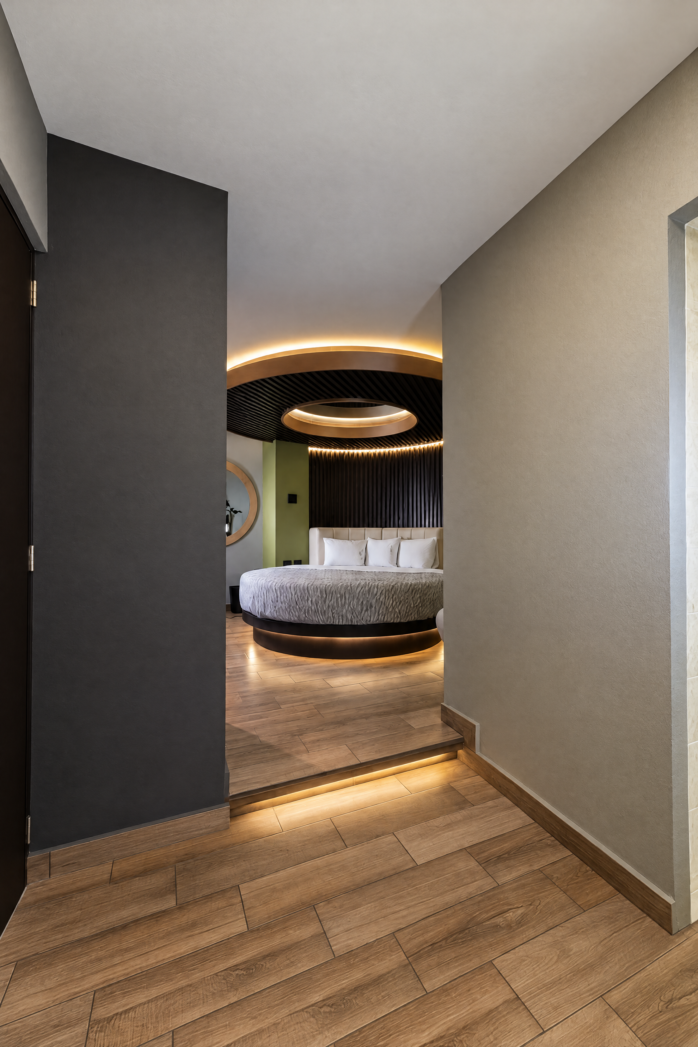 Vista desde el acceso hacia una habitación con cama redonda e iluminación cálida